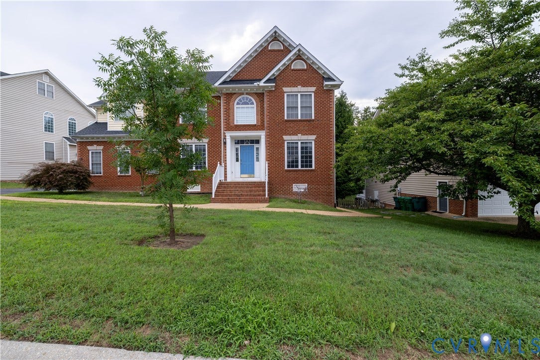 Brick facade with white trim accents and a vibrant blue entry door