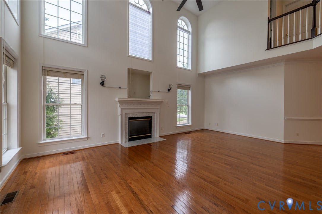 Hardwood flooring and high ceilings with multiple windows