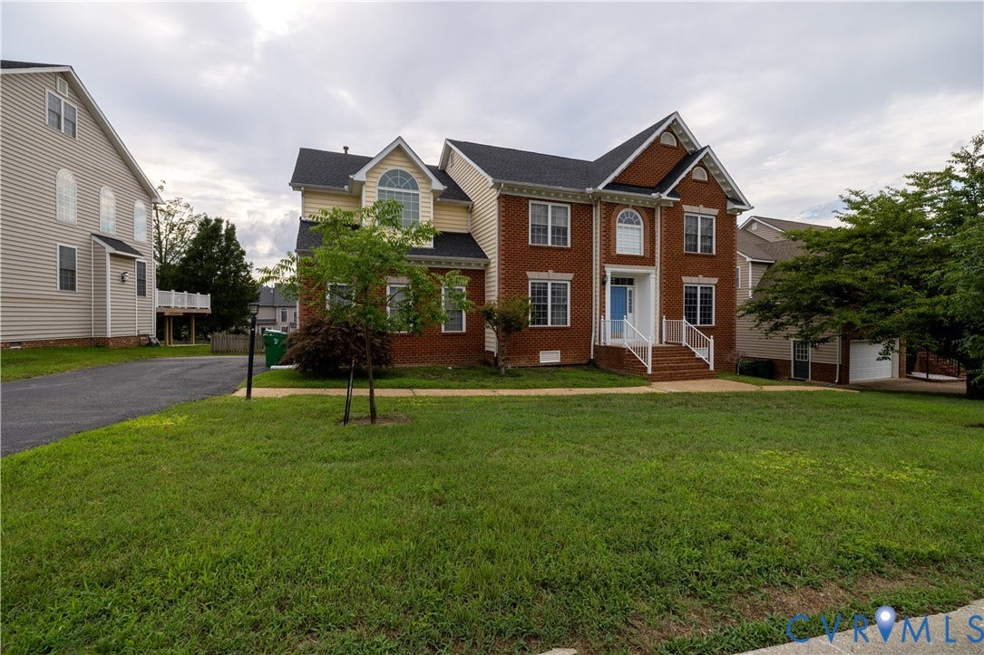 Brick and siding exterior with a light blue entry door, an arched transom window, and white porch railings