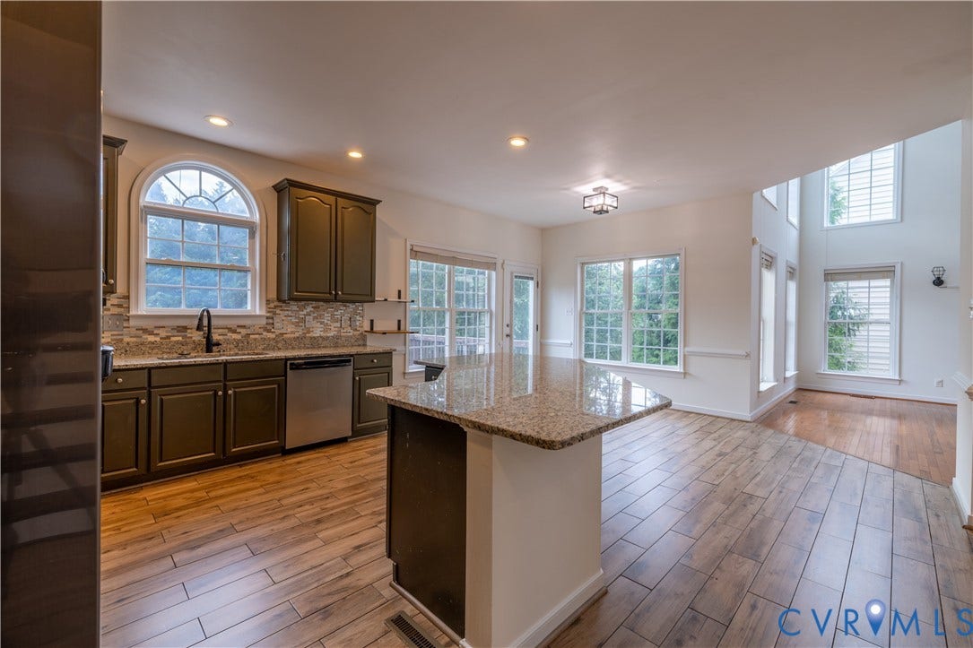 Kitchen featuring olive cabinetry, granite countertops, tile backsplash, and wood-finish flooring