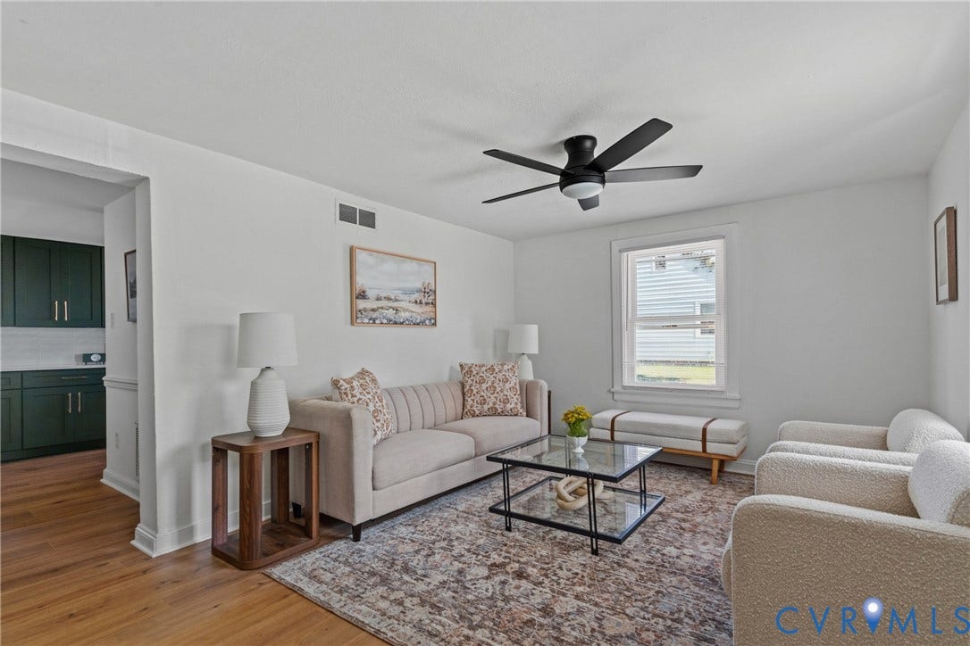 7406 Alycia Avenue, Henrico, VA 23228 Bright living area with wood-finish flooring, a contemporary ceiling fan, and white walls