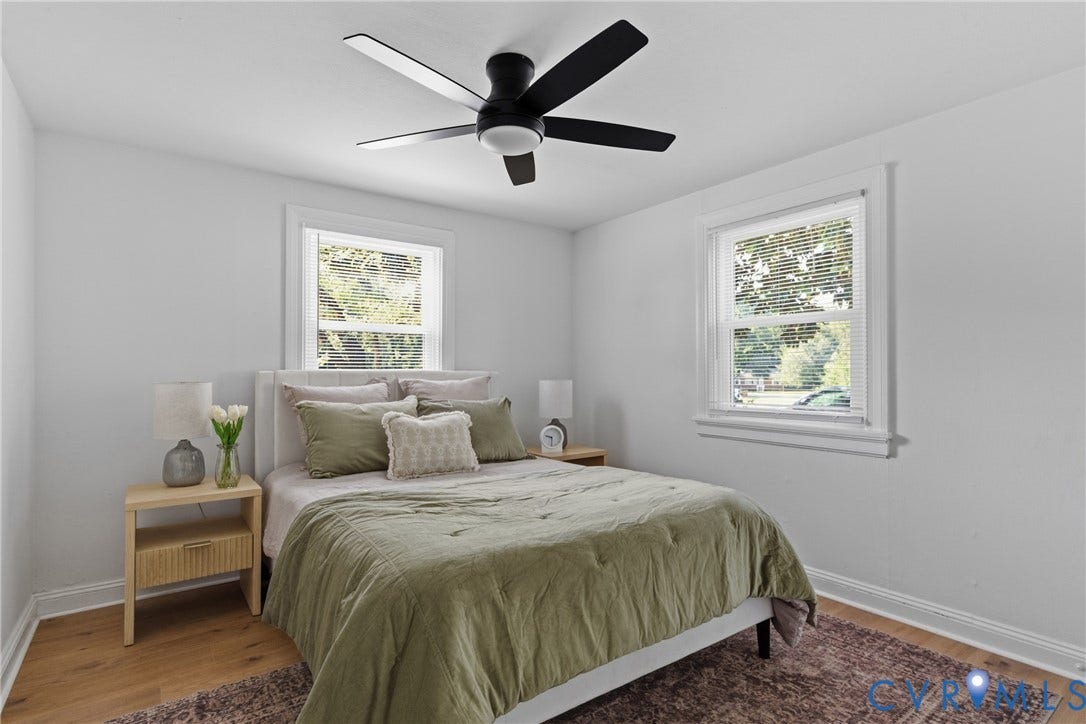 7406 Alycia Avenue, Henrico, VA 23228 Light-filled room featuring two windows, a ceiling fan with integrated lighting, and wood-finish flooring