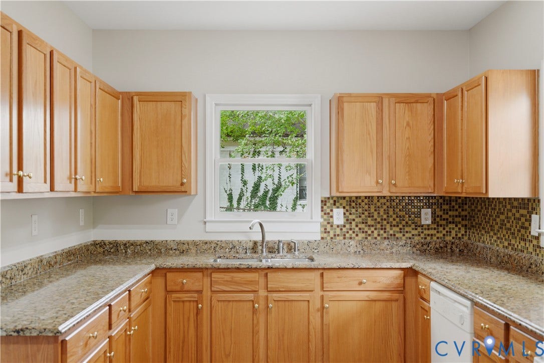 124 Lipscomb Street, Blackwell, Richmond, VA 23224 U-shaped kitchen with wood cabinetry, speckled countertops, stainless steel sink, and mosaic tile backsplash