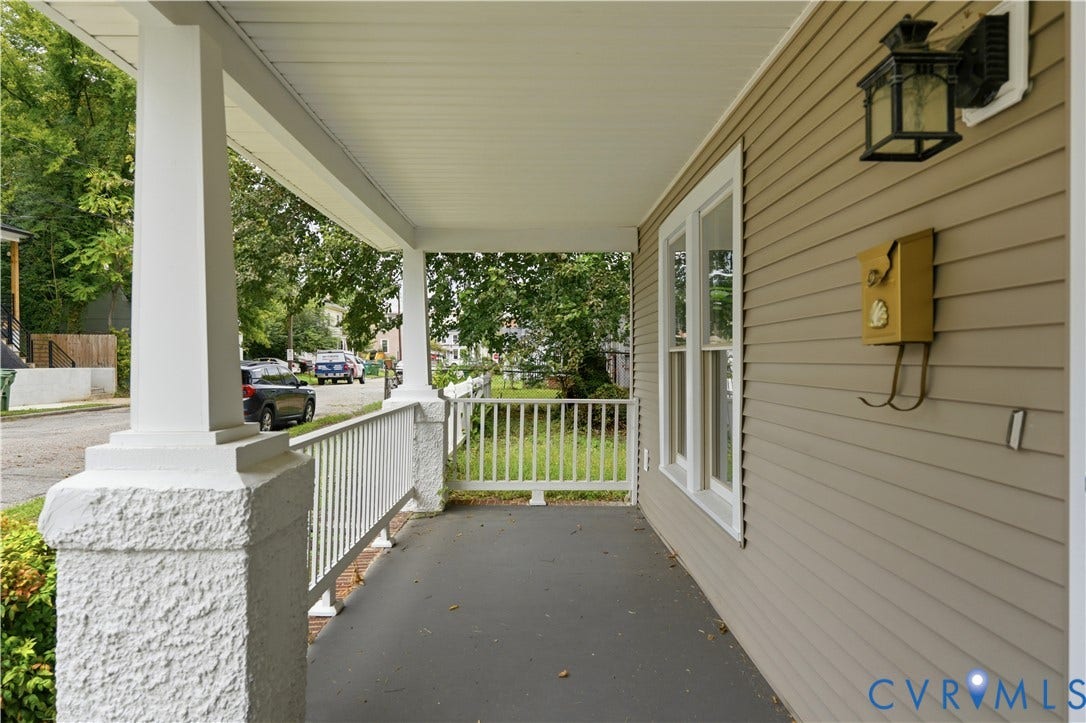 124 Lipscomb Street, Blackwell, Richmond, VA 23224 Covered porch with white columns, matching railing, horizontal siding, and an exterior light fixture