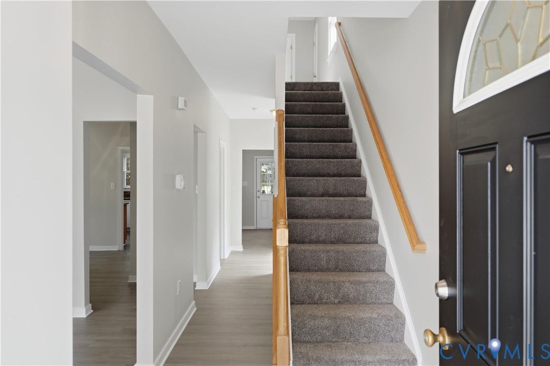 124 Lipscomb Street, Blackwell, Richmond, VA 23224 Entryway featuring wood-finish flooring, a carpeted staircase, and a wood handrail