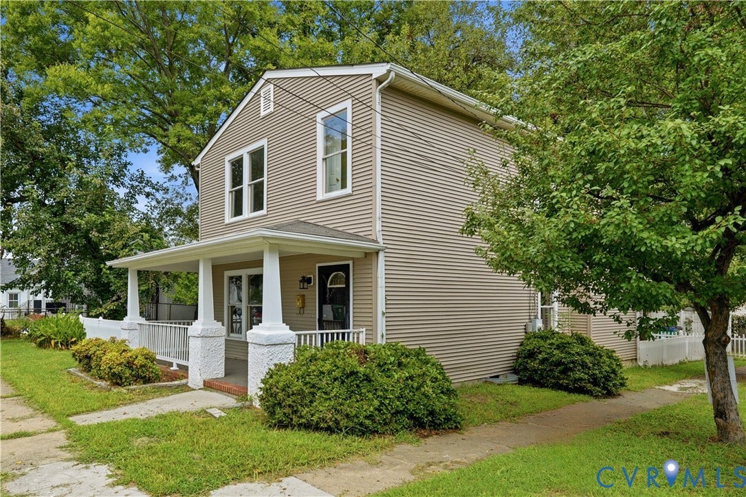 124 Lipscomb Street, Blackwell, Richmond, VA 23224 Two-story exterior with horizontal siding, covered front porch, white porch railing, and mature trees