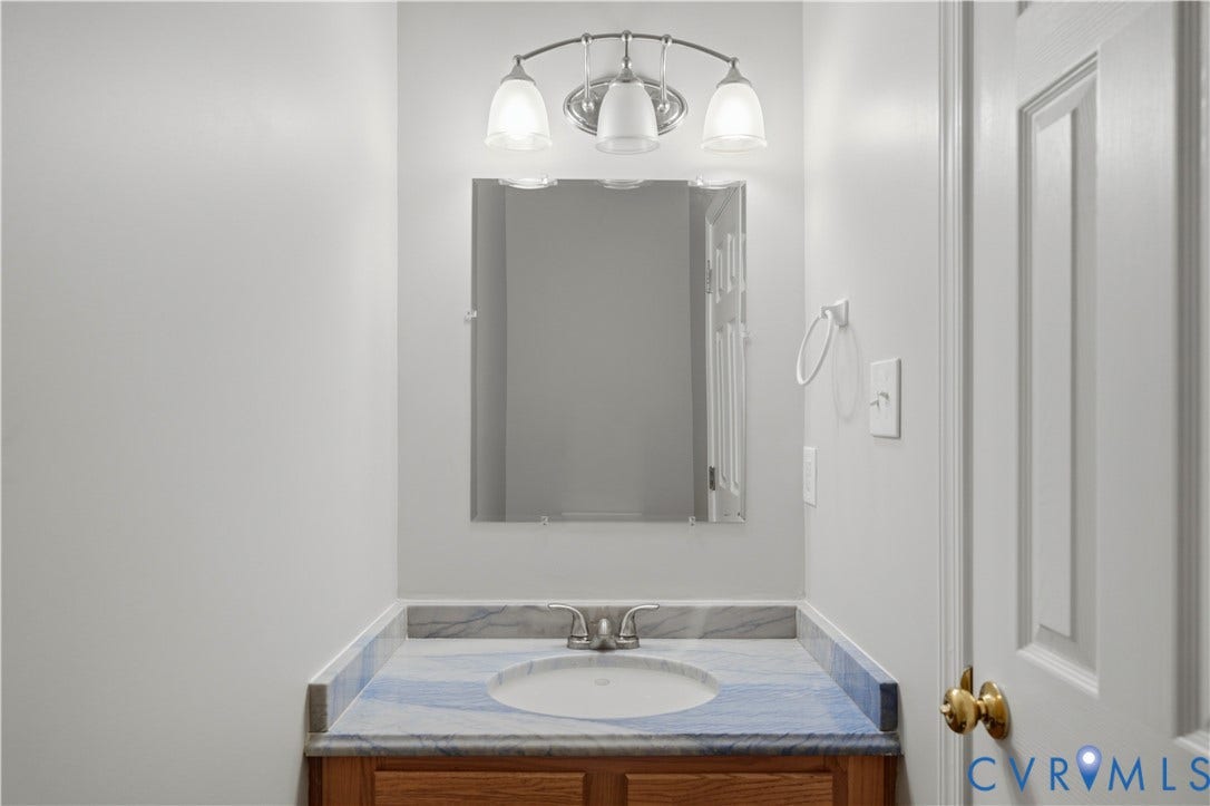 124 Lipscomb Street, Blackwell, Richmond, VA 23224 Vanity with wood-finish cabinetry, integrated sink, and an elegant stone-look countertop
