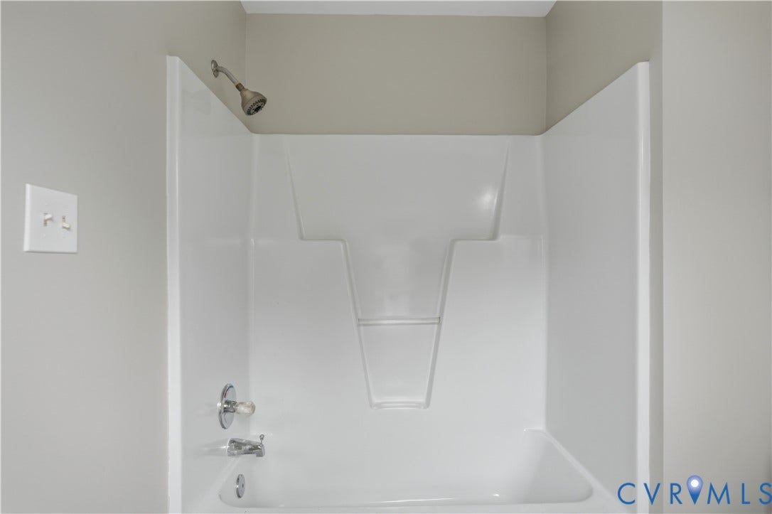 124 Lipscomb Street, Blackwell, Richmond, VA 23224 White bathtub and shower combination with a chrome shower head and faucet
