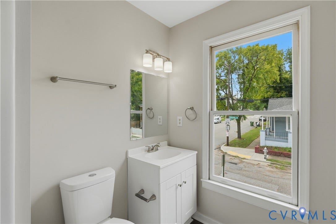 124 Lipscomb Street, Blackwell, Richmond, VA 23224 White vanity with integrated sink, brushed nickel lighting fixture, and white toilet