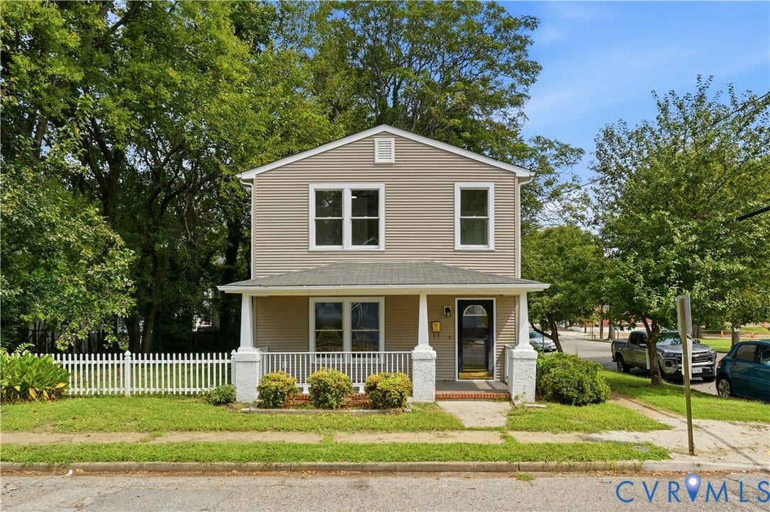 124 Lipscomb Street, Blackwell, Richmond, VA 23224 Two-story exterior with siding, covered front porch with white columns, front entry door with transom window, white picket fence, and mature trees