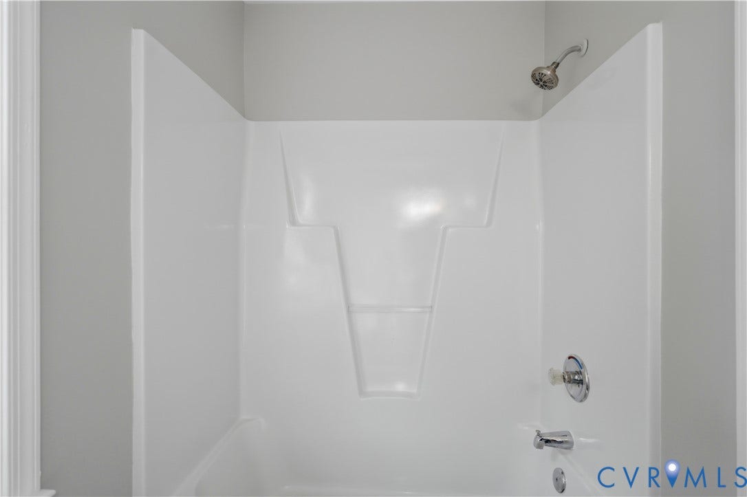 124 Lipscomb Street, Blackwell, Richmond, VA 23224 Integrated white bathtub and shower unit with chrome fixtures