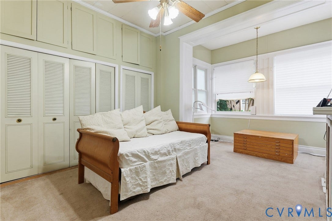 1505 Grove Avenue, Fan, Richmond, VA 23220 Carpeted room featuring multiple windows with blinds, built-in louvered bi-fold closet doors, and overhead cabinetry