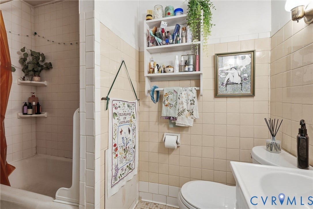 1505 Grove Avenue, Fan, Richmond, VA 23220 Built-in bathtub with tiled surround, wall-mounted shelving, and a toilet