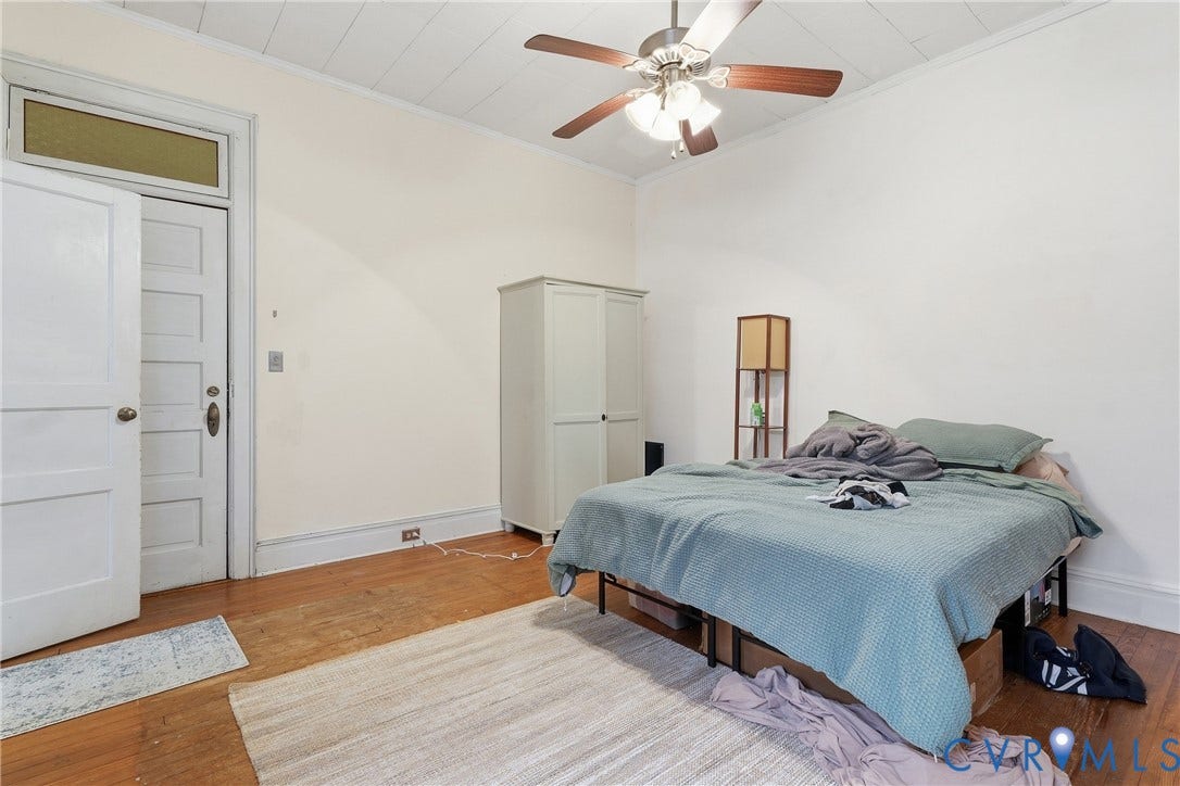 1505 Grove Avenue, Fan, Richmond, VA 23220 Hardwood-style flooring with a decorative area rug, overhead ceiling fan with light, and a paneled door with transom window