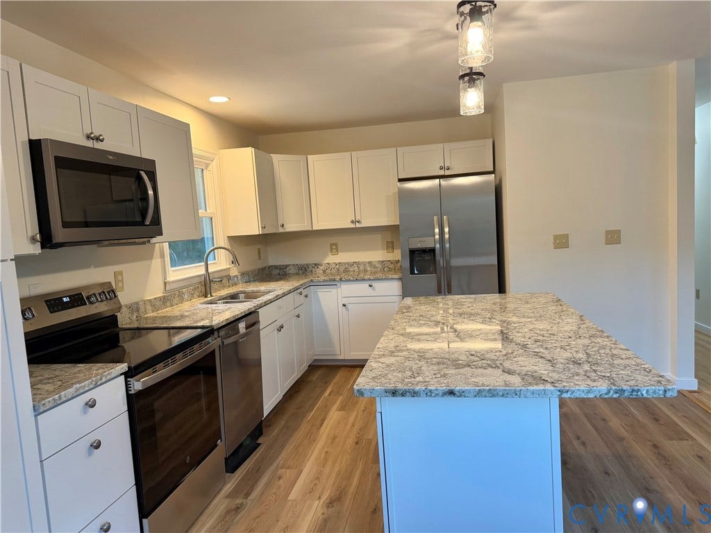1605 Cartersville Road, Quiet, Goochland, VA 23063 Kitchen featuring wood-finish flooring, white cabinetry, stainless steel appliances, and light-toned countertops