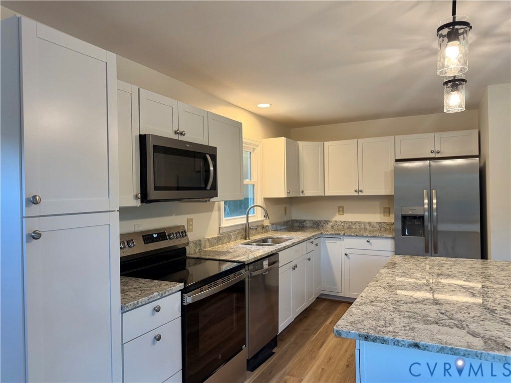 1605 Cartersville Road, Quiet, Goochland, VA 23063 White cabinetry with stainless steel appliances, speckled stone countertops, and wood-finish flooring