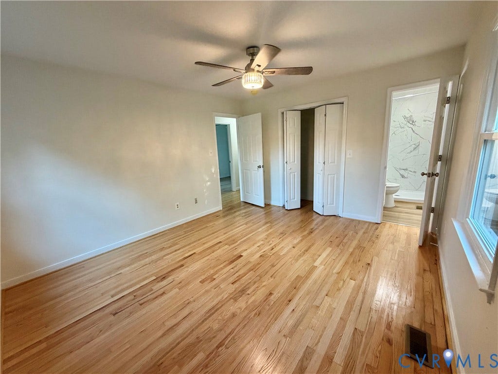 1605 Cartersville Road, Quiet, Goochland, VA 23063 Wood-finish flooring, ceiling fan with light fixture, bifold closet doors, and an en-suite bathroom featuring a tiled shower surround