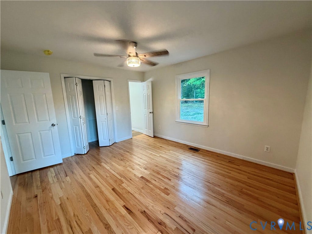 1605 Cartersville Road, Quiet, Goochland, VA 23063 Hardwood flooring, ceiling fan with integrated lighting, white paneled doors, and a double-door closet