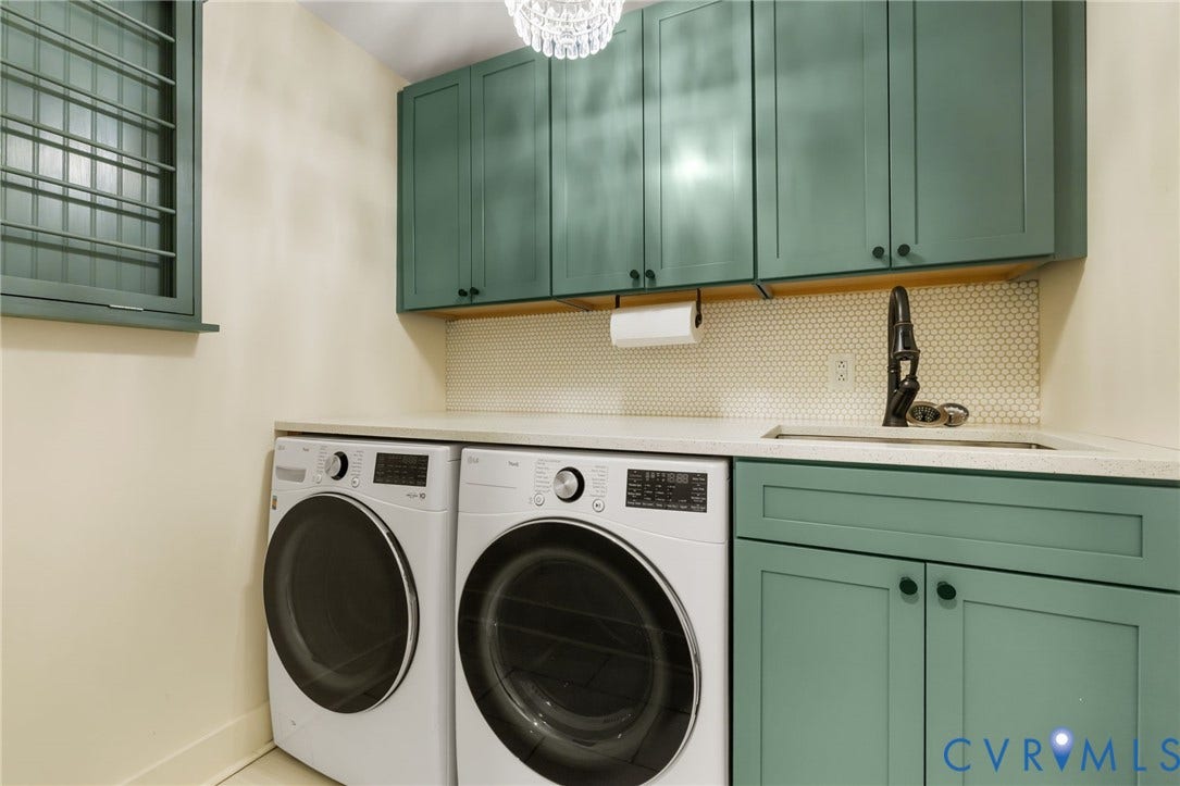 Teal cabinetry, white countertop, hexagon tile backsplash, and a modern black faucet complete this space