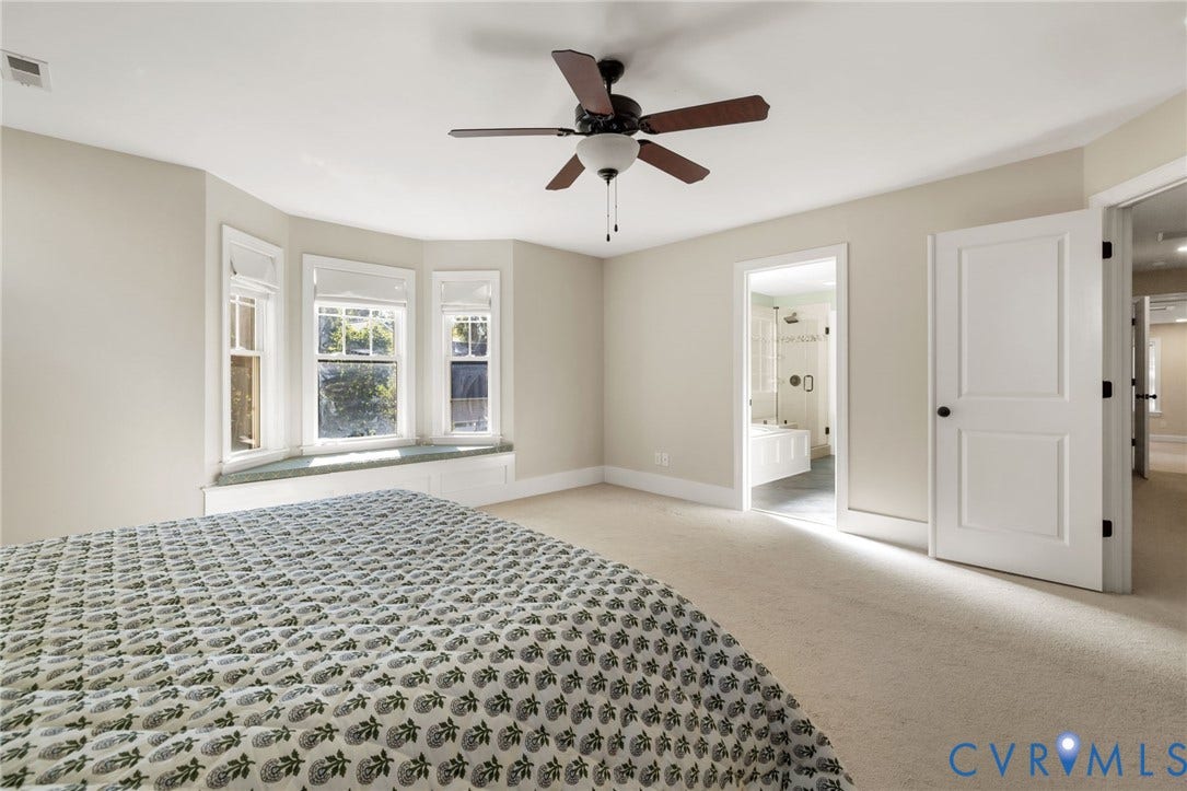 Recessed lighting, ceiling fan, bay window with built-in storage, and neutral carpeting