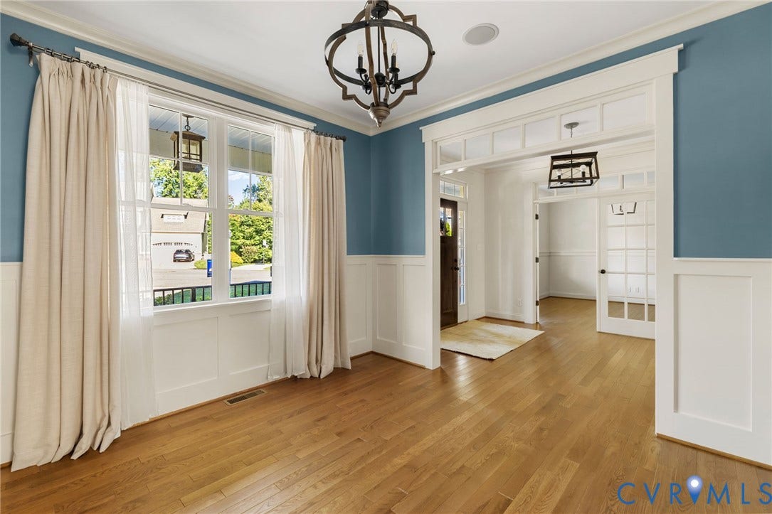 Hardwood flooring throughout, with wainscoting and crown molding