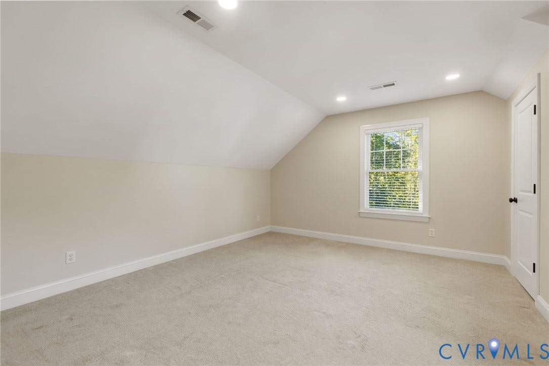 Carpeted room with a single window, white trim, and recessed lighting