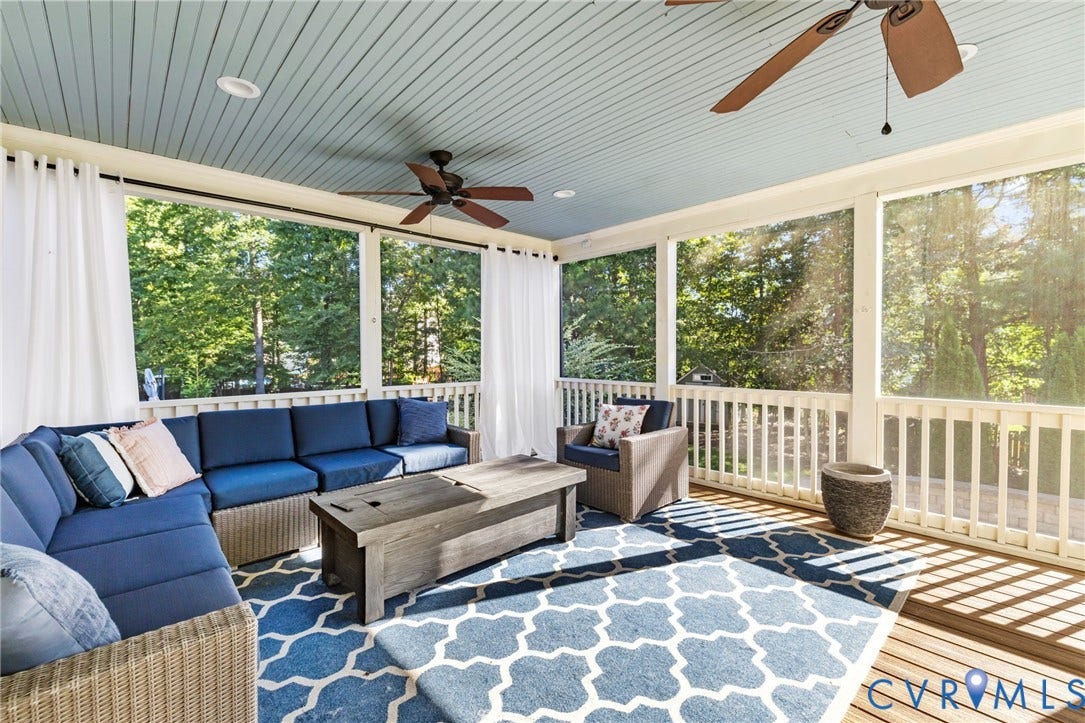 Screened porch with wood-finish flooring, light blue beadboard ceiling, and integrated ceiling fans