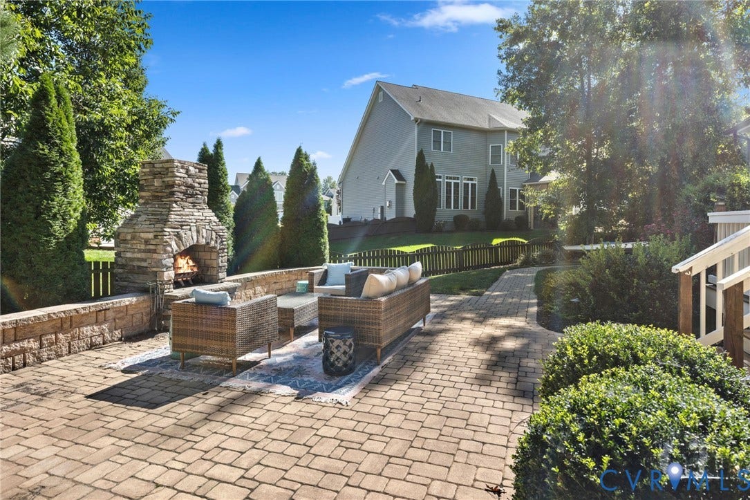 Expansive paver patio with a stone-clad outdoor fireplace