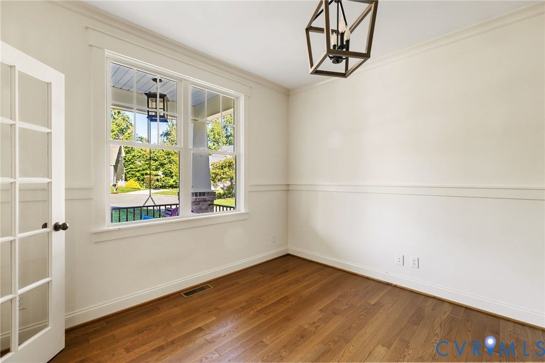 Hardwood flooring, French-style glass paneled door, crown molding, double-hung window, and decorative wall trim