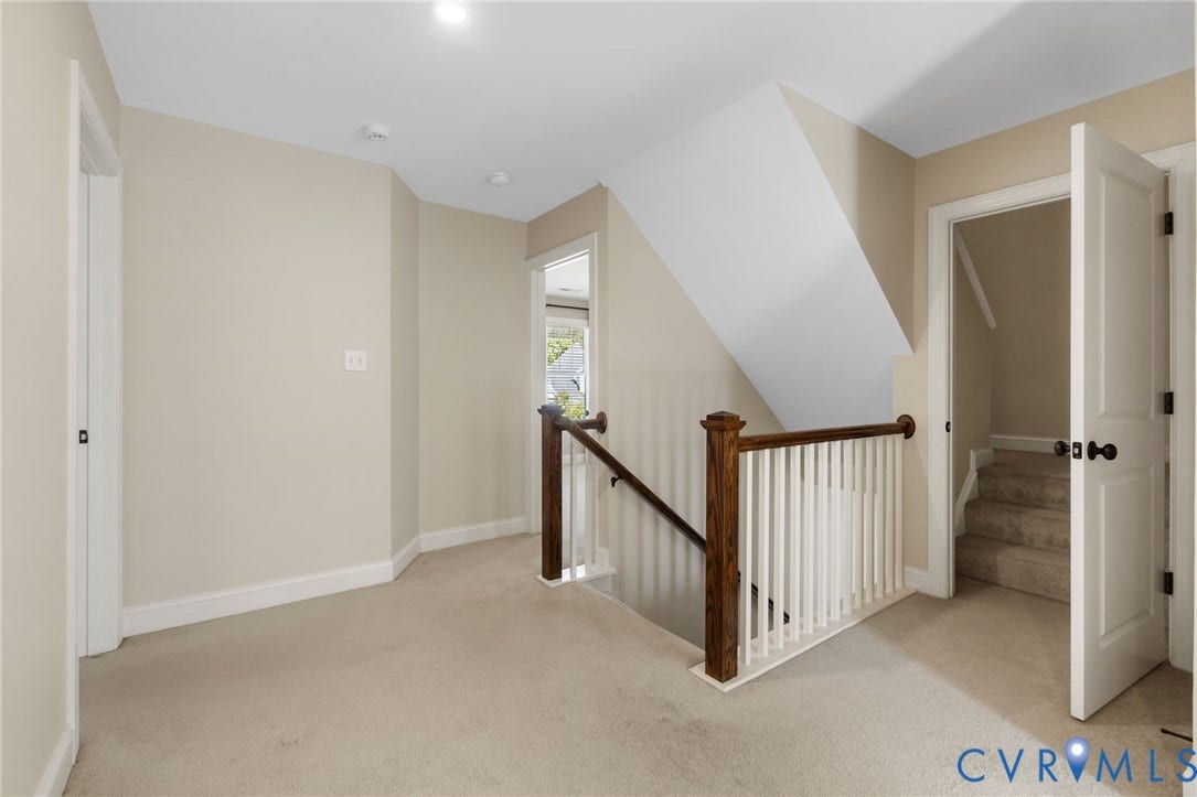 Carpeted landing featuring a wood and white spindle stair railing, recessed lighting, and white interior doors with dark hardware