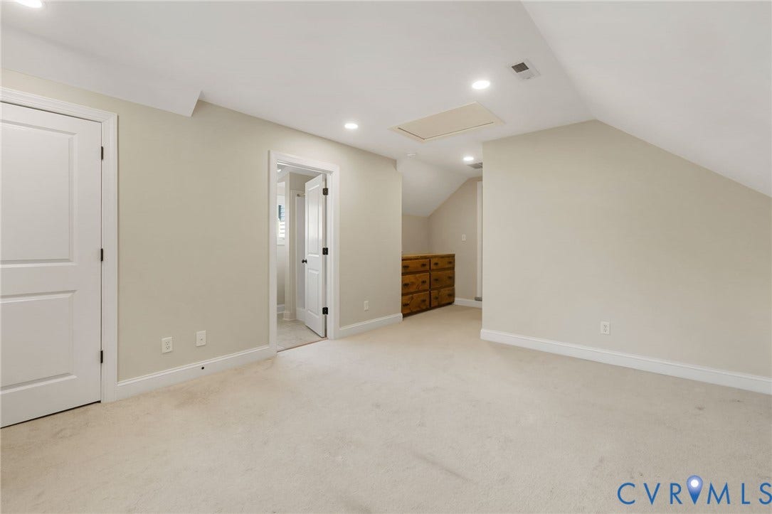Carpeted flooring, recessed lighting, white interior doors, and a built-in wooden cabinet