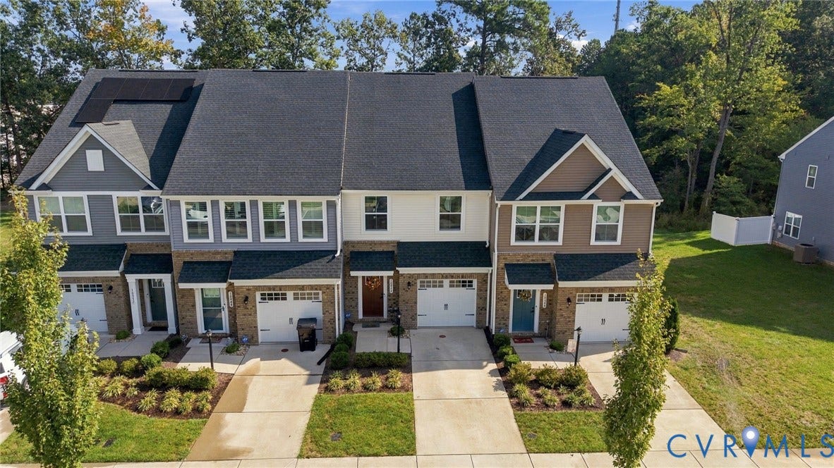 Townhome exteriors feature multi-tone siding, brick accents, and attached garages