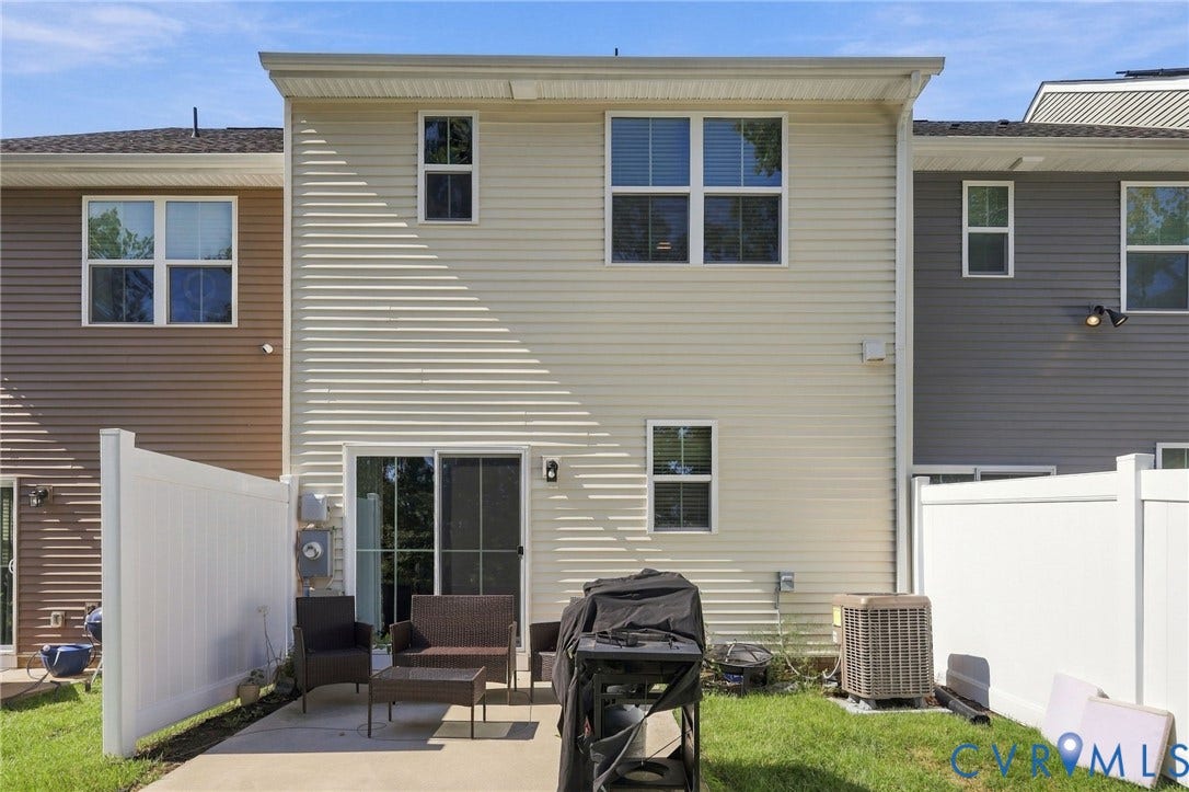 Rear exterior with light-colored siding and multiple windows