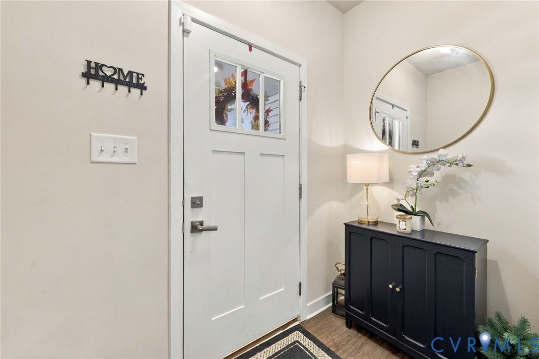 Entryway featuring a paneled door with glass inserts, wood-finish flooring, and light-toned walls