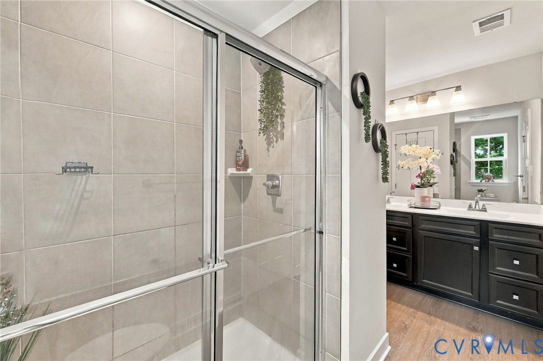 Glass-enclosed shower with subway tile surround