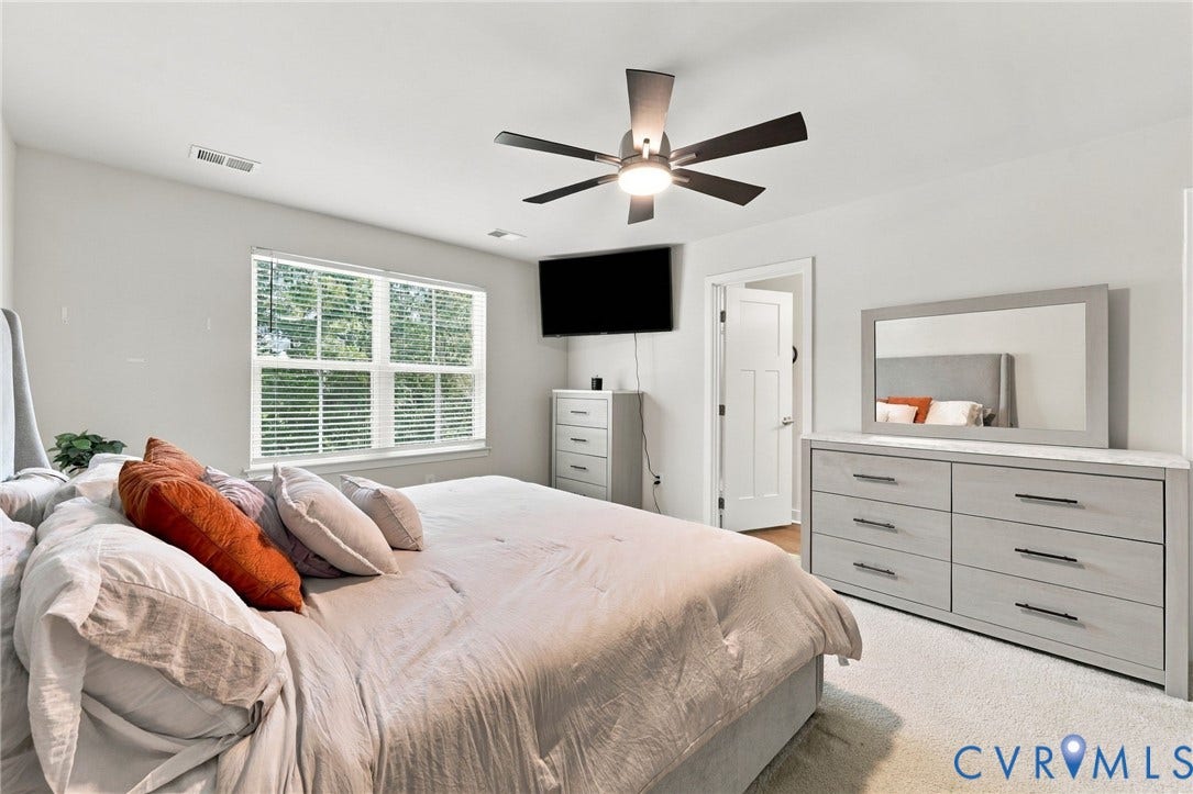Ceiling fan with integrated lighting, window with blinds, light-colored carpeting, white interior door with paneling