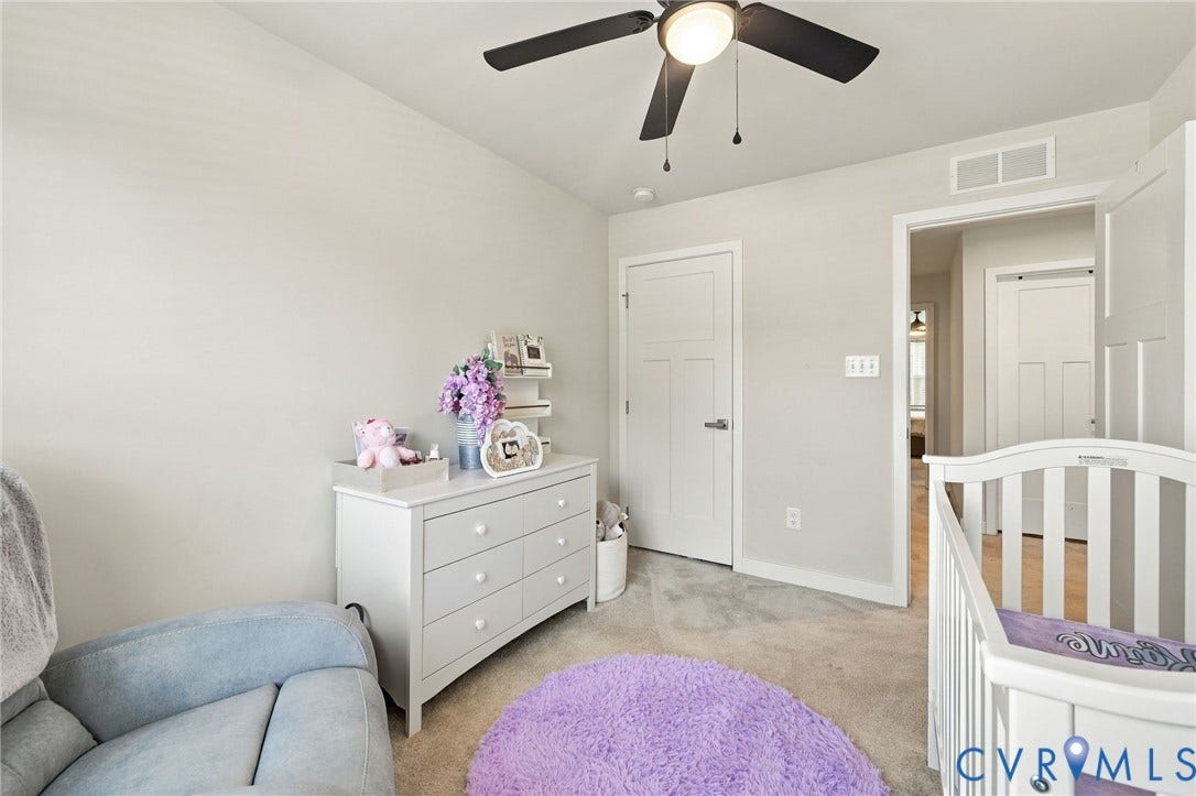 Neutral wall color, ceiling fan with integrated lighting, paneled interior doors, and carpet flooring