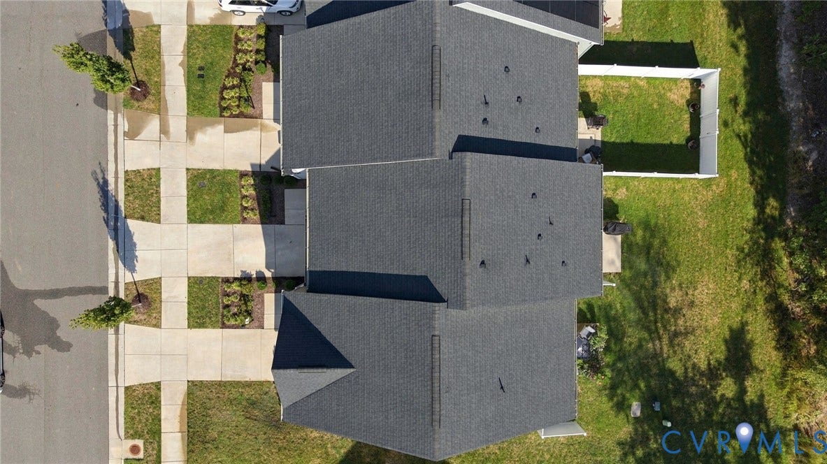 Asphalt shingle roofing, street frontage with sidewalk, manicured lawn, and a fenced backyard