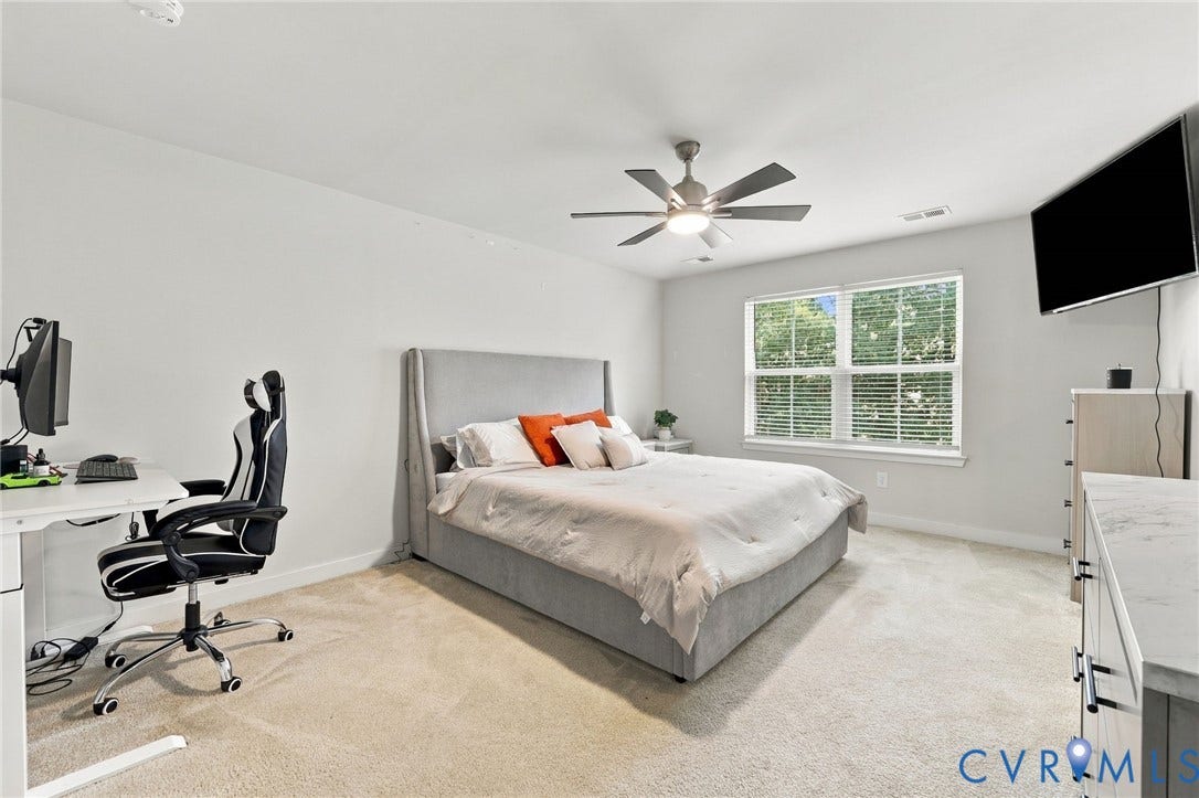 Wall-to-wall carpeting, window with blinds, ceiling fan with integrated lighting, and neutral wall tones