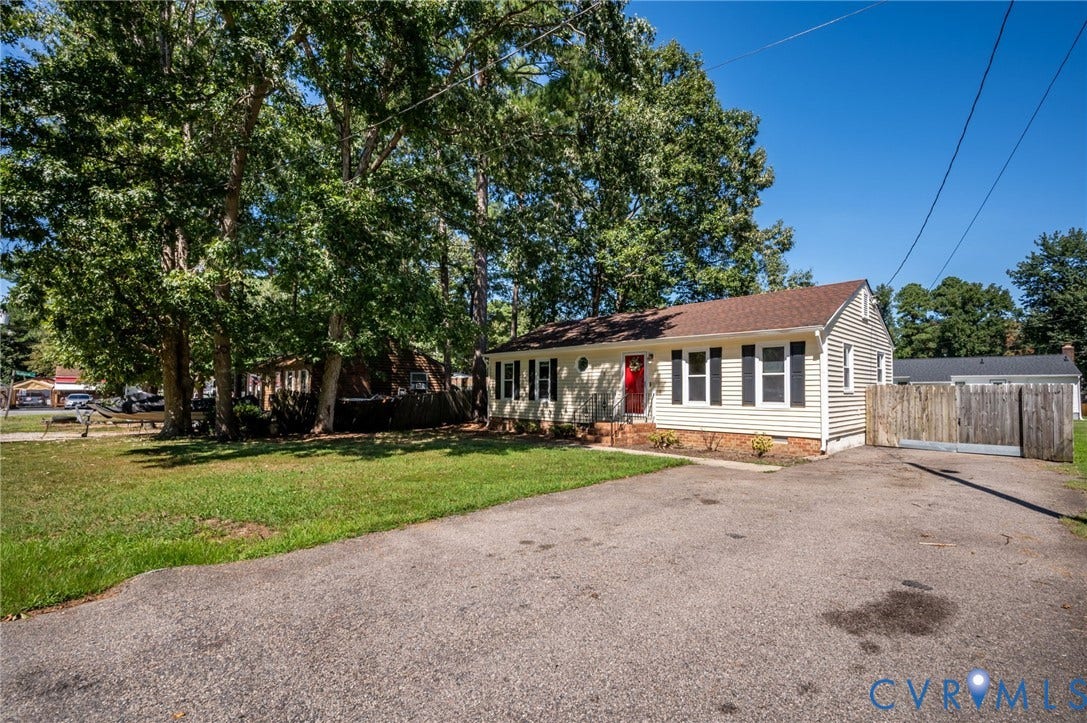 3530 Glisson Road, Richmond, VA 23237 Light-colored siding exterior, red entry door, brown shingle roof, black window shutters, and a gravel driveway