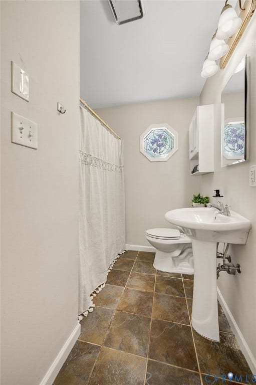 3530 Glisson Road, Richmond, VA 23237 Pedestal sink, wall-mounted mirror, square tile flooring, decorative octagonal window, and wall-mounted storage cabinet