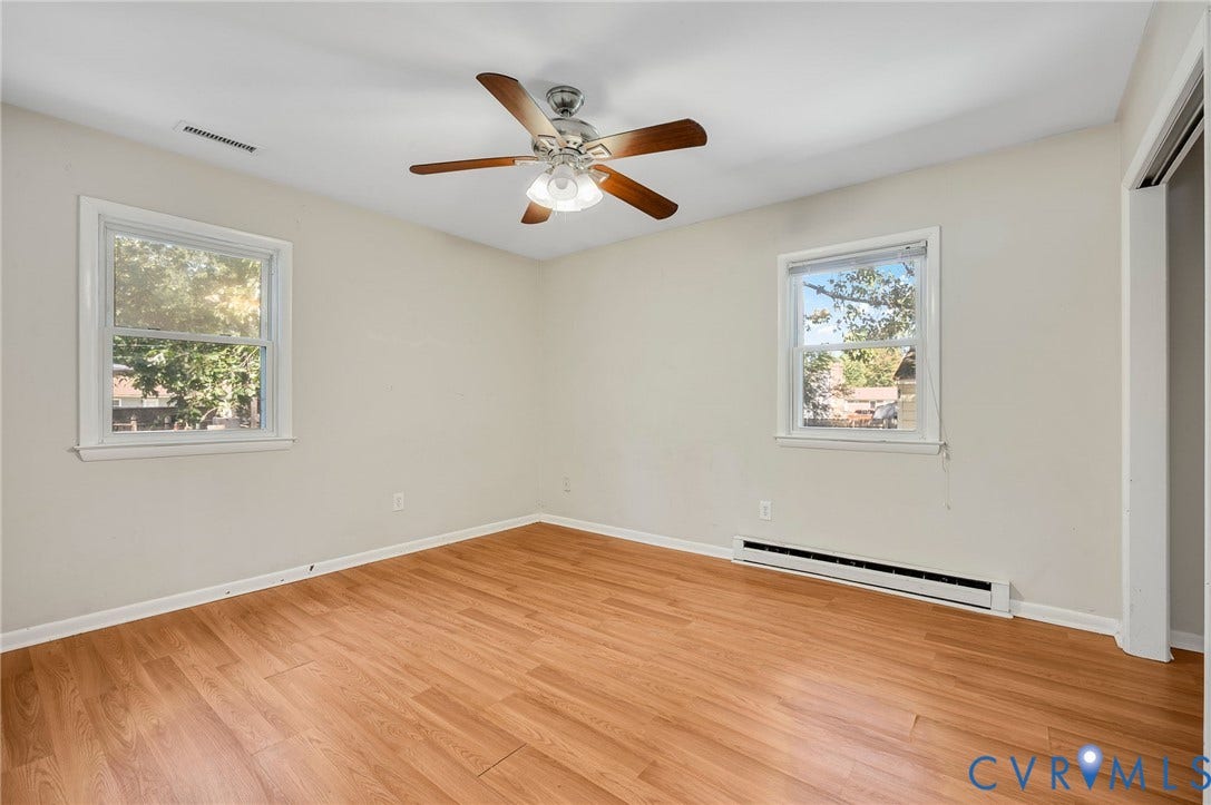 3530 Glisson Road, Richmond, VA 23237 Wood-finish flooring, two windows, ceiling fan with light fixture, and light-colored wall paint