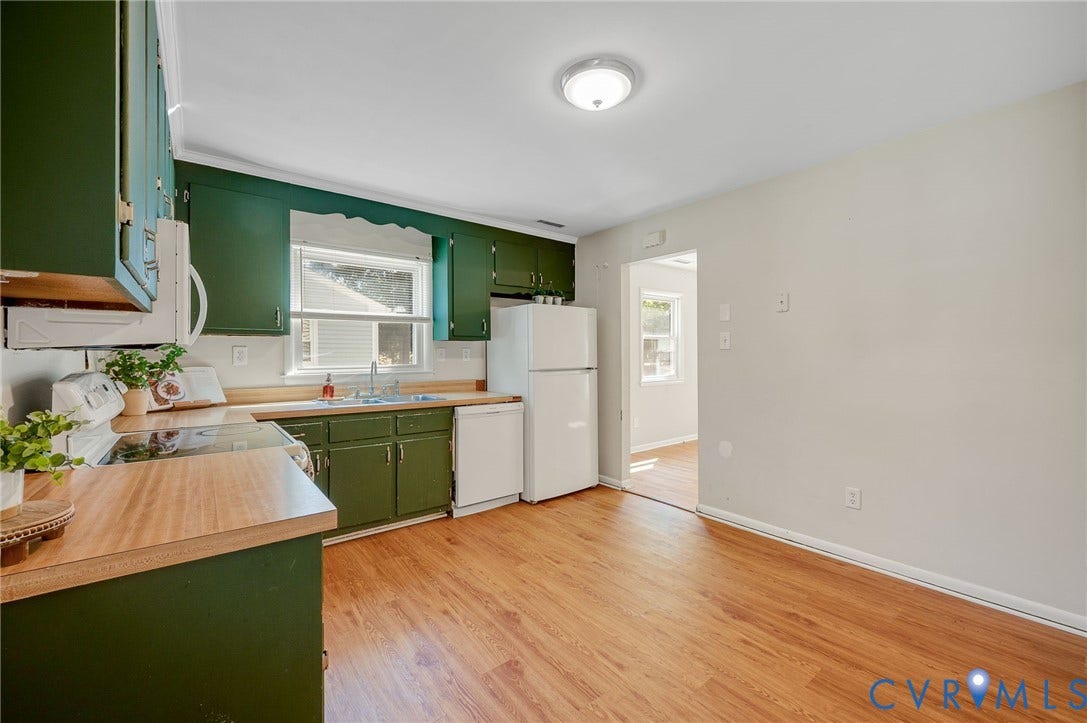 3530 Glisson Road, Richmond, VA 23237 Kitchen with wood-finish flooring, green cabinetry, white appliances, and a window above the sink