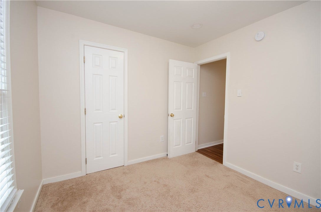 Neutral tone wall paint, textured carpeting, white trim, paneled interior doors, and recessed ceiling lighting