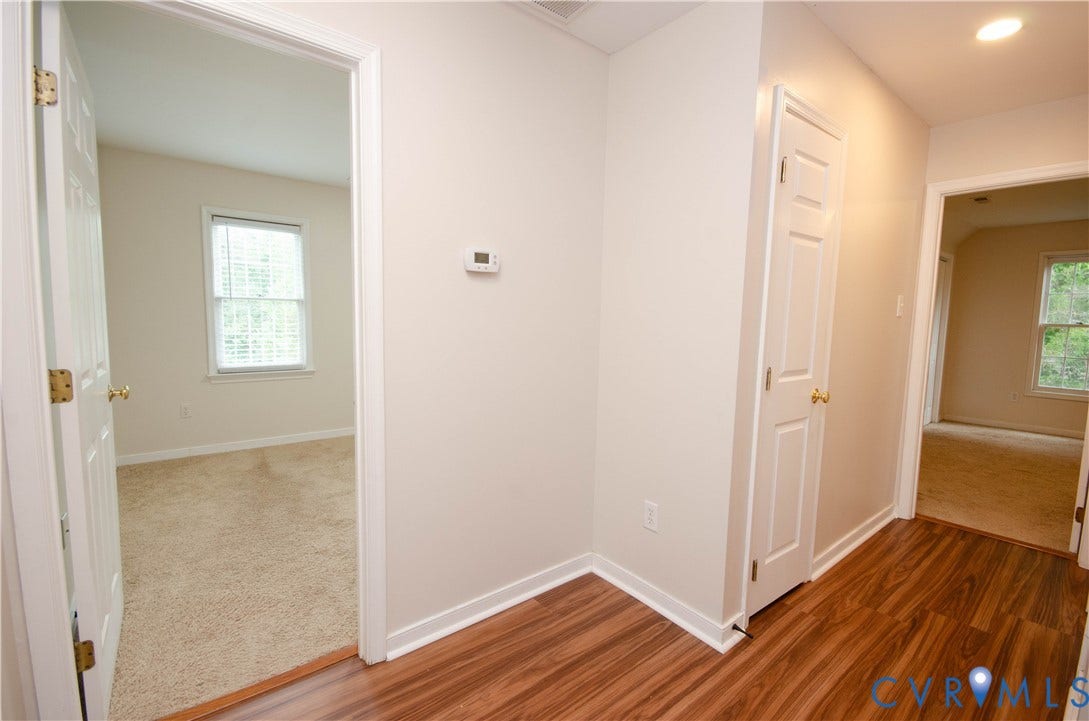 Wood-finish flooring, neutral wall paint, white trim, and recessed lighting