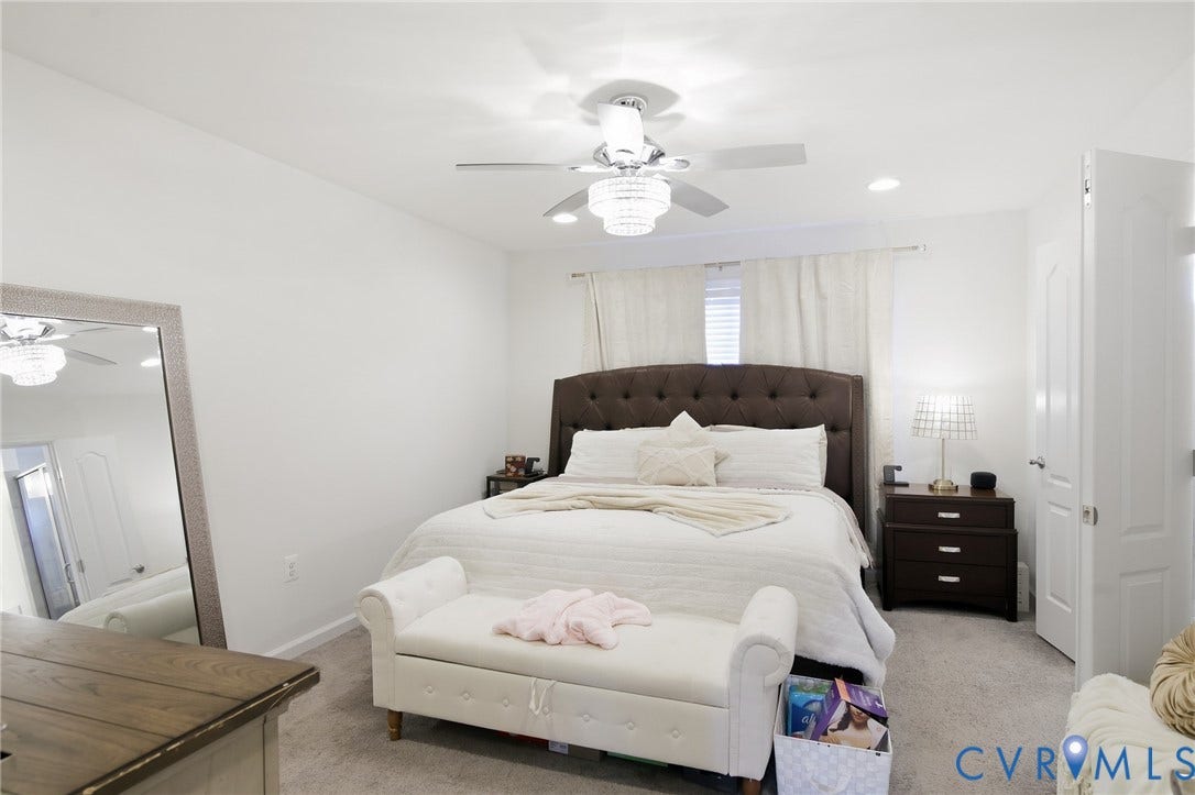 Plush carpeted flooring, white walls, recessed lighting, and ceiling fan with an integrated chandelier