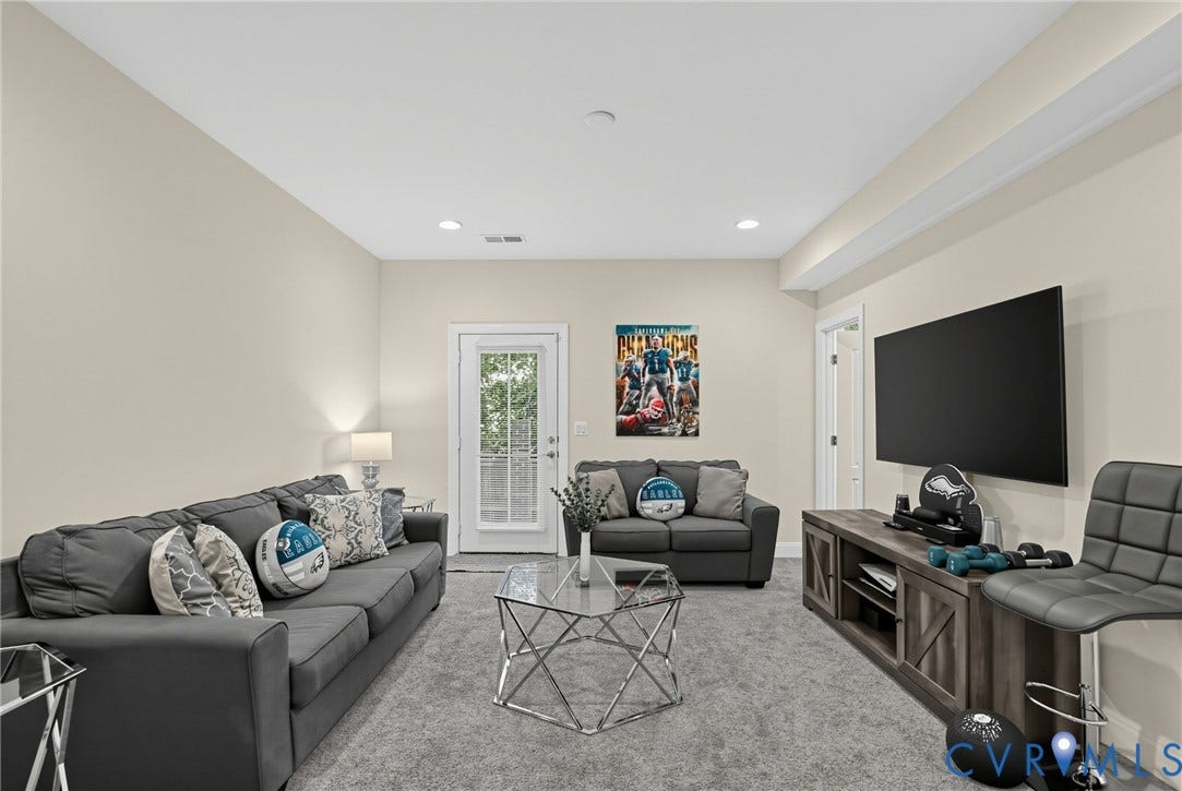 Recessed lighting, light neutral wall color, glass panel door, built-in media console, and neutral carpeting