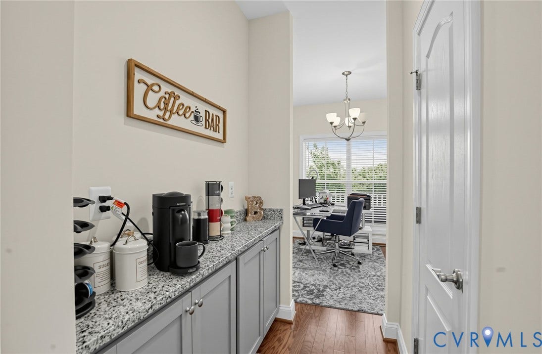 Integrated countertop with gray cabinetry, wood-finish flooring, and a chandelier lighting fixture