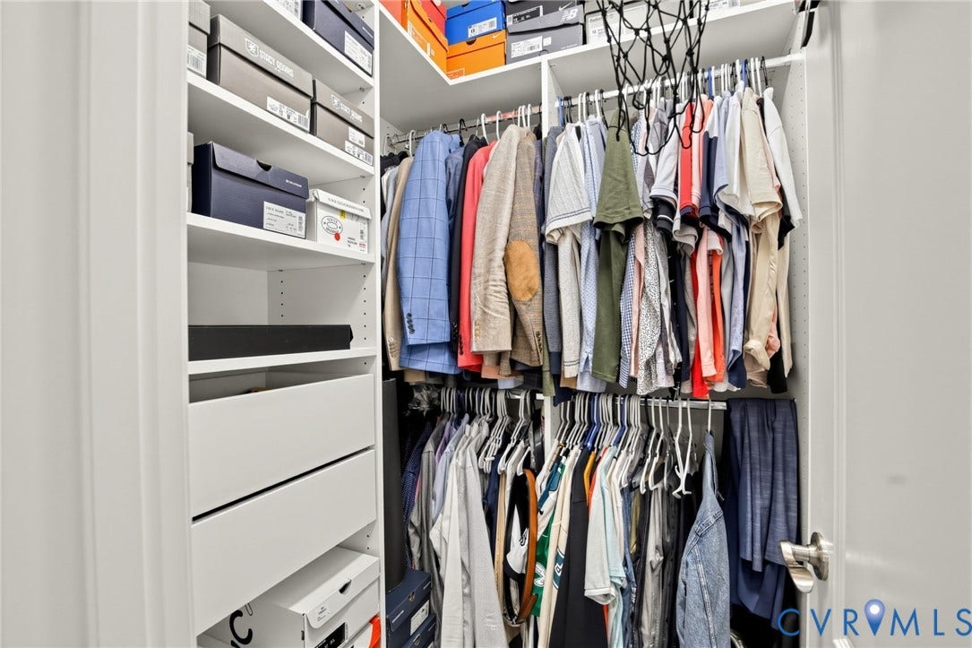 Custom closet system featuring multiple hanging rods, integrated shelving, and built-in drawers