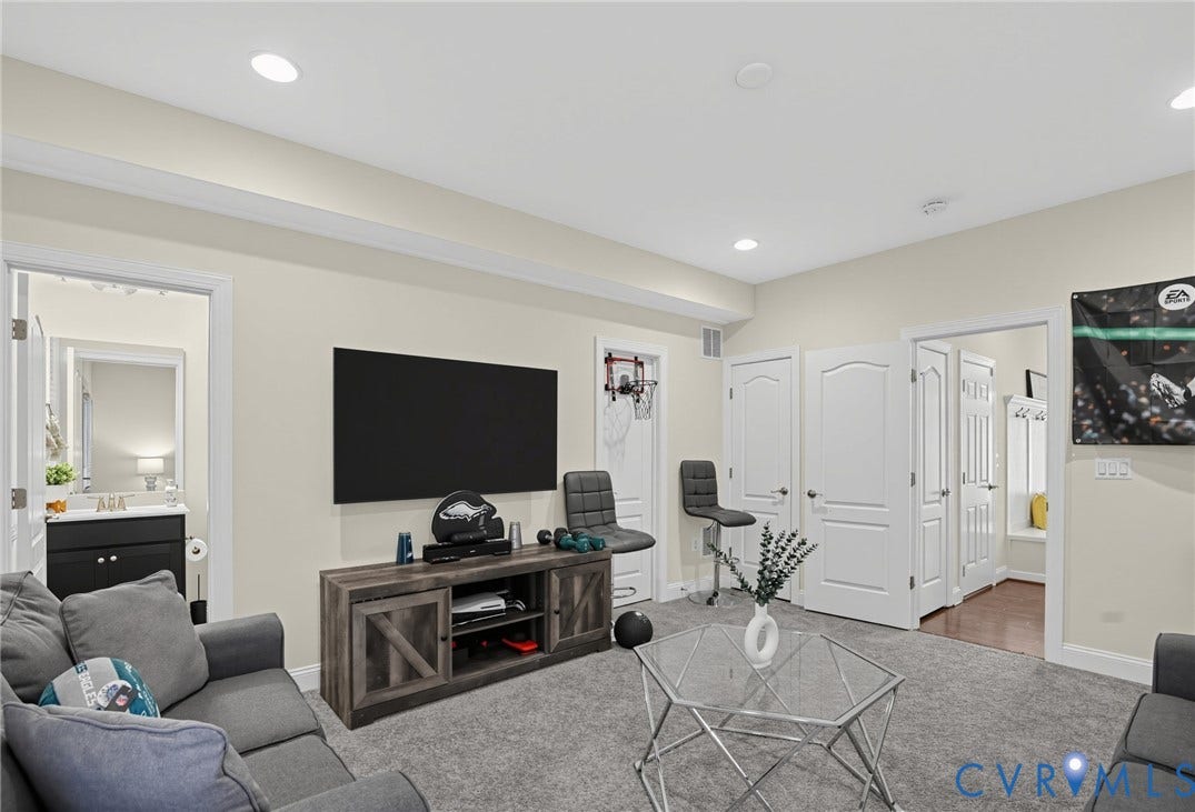Recessed lighting, light-toned wall finishes, and multiple paneled doors